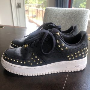 Black Nike Air Force 1s with gold stars